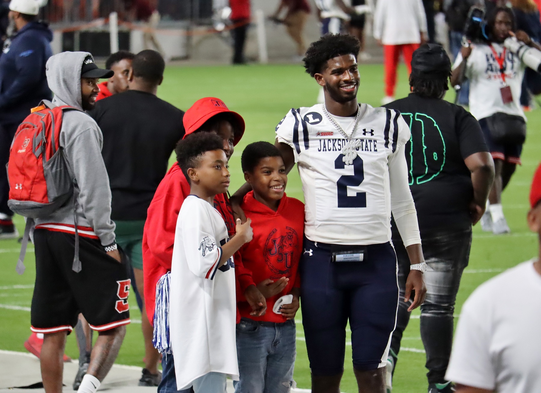 Shedeur Sanders in a Jackson State uniform with young fans on the field